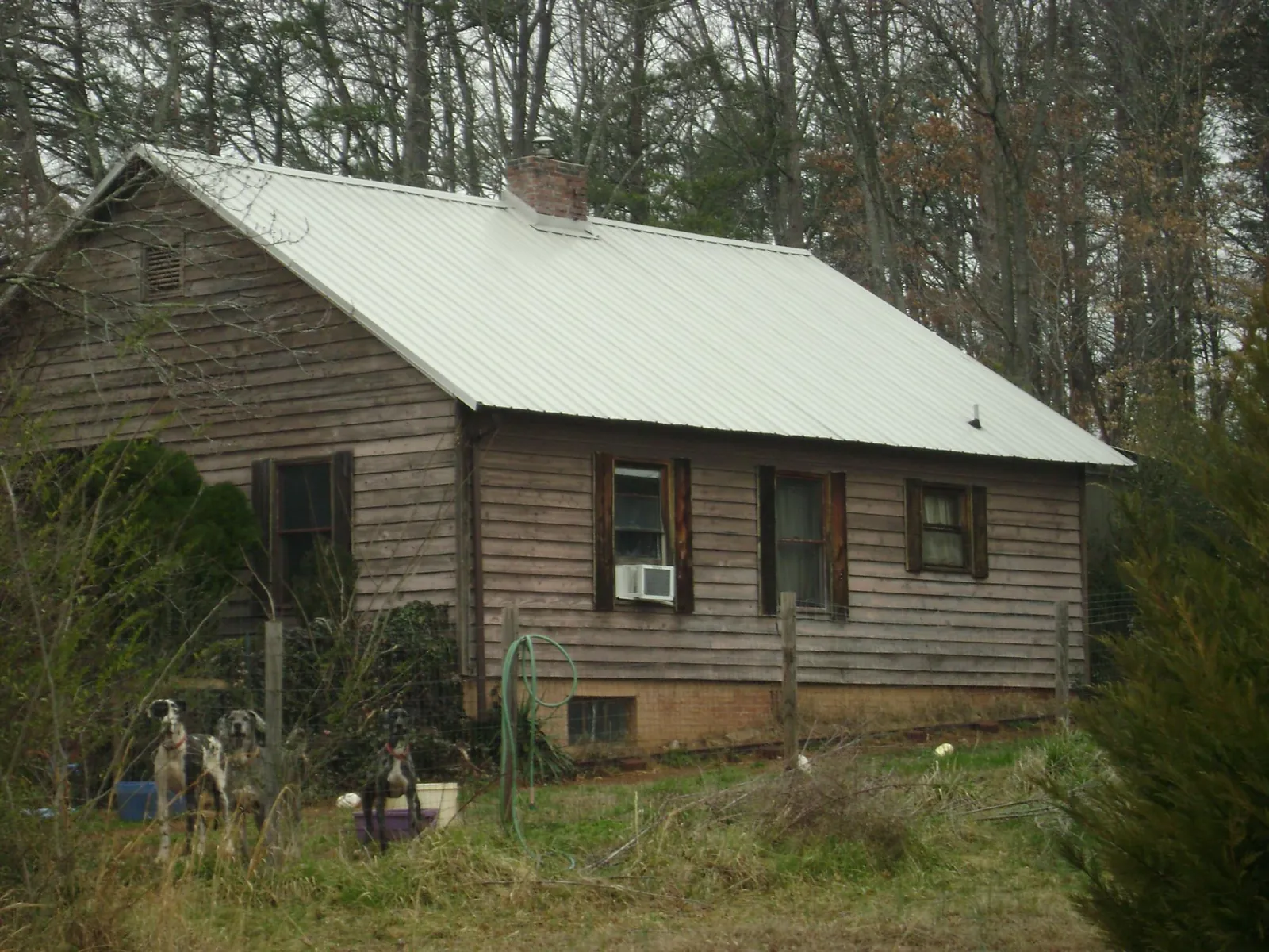 White metal roof on an old wood sided farmhouse, from a Metal Roof Installation job in Harvey